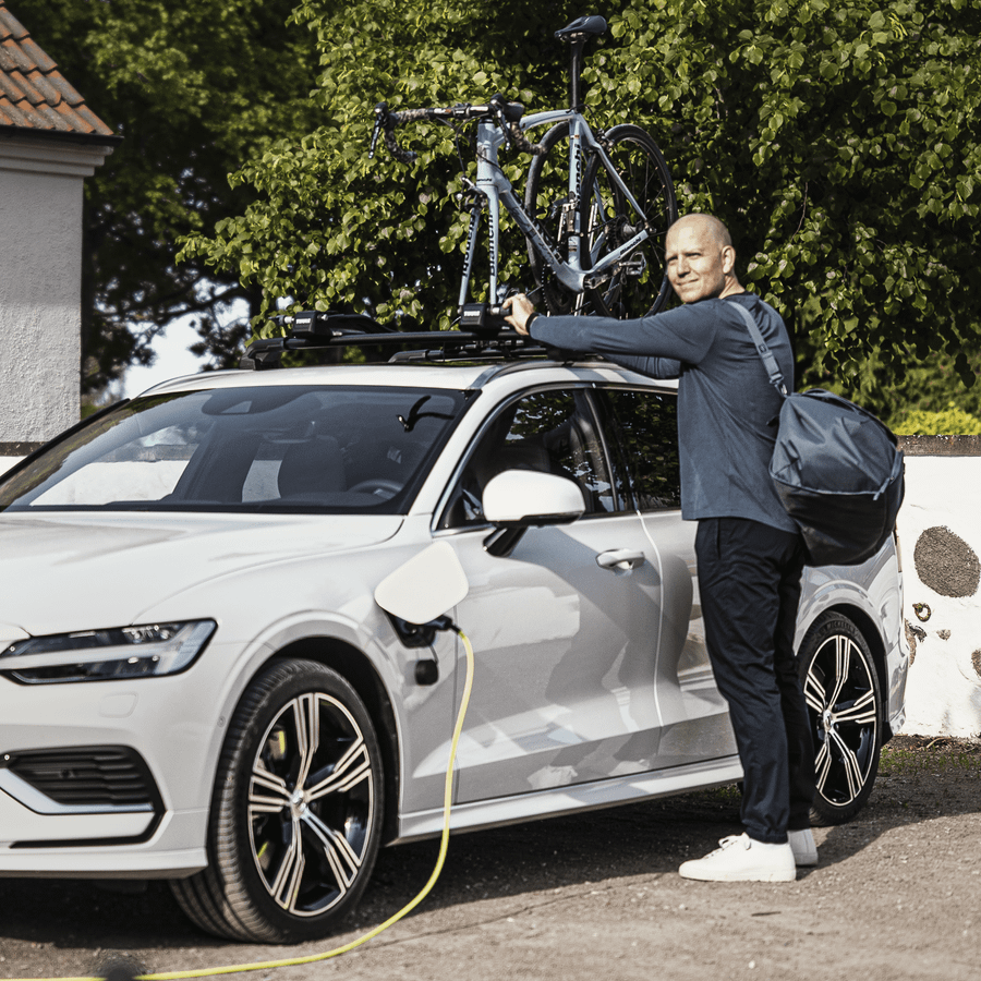 A man loading their bikes into the Thule FastRide roof bike rack.