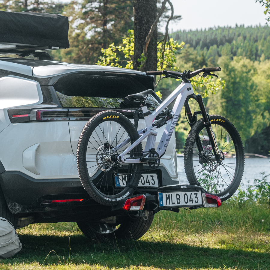 Thule VeloLite towbar bike carrier mounted on the back of a car, with a bike secured on the bike carrier.
