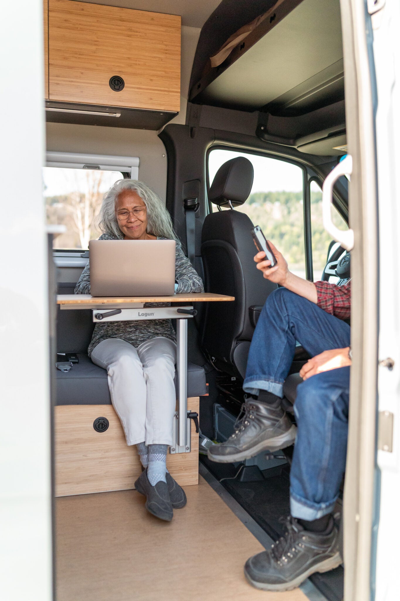 Reisende arbeiten an einem Lagun Tisch im Camper